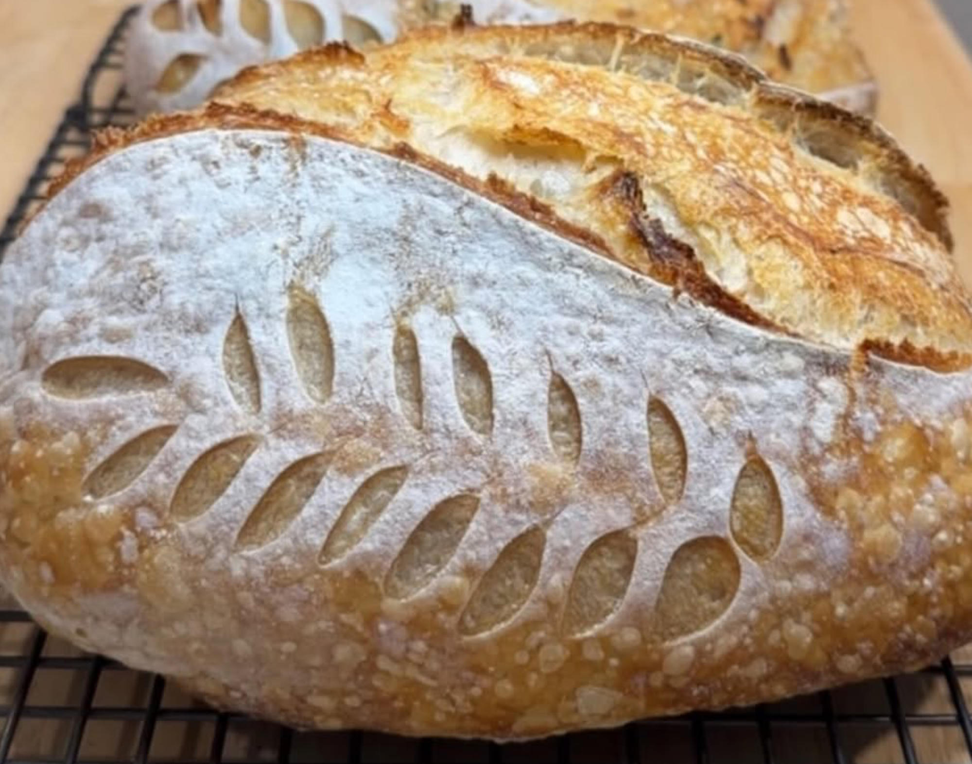 Classic sourdough loaves from Lone Star Bread Co., scored and dusted with flour, cooling on a wire rack.